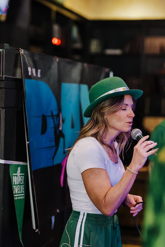 Vocalist in green derby hat delivering a soulful moment