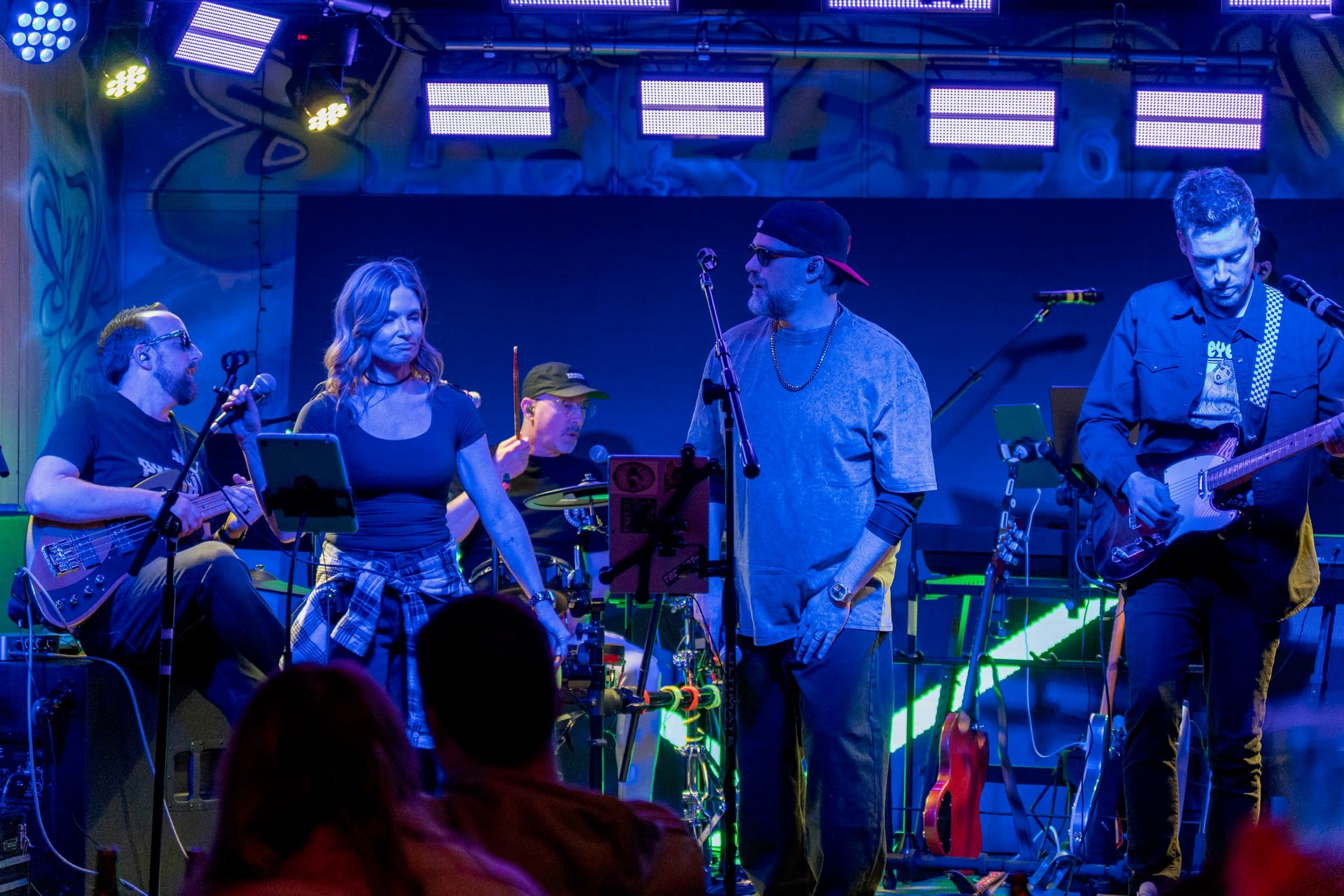 Full band rocking out under colored stage lights